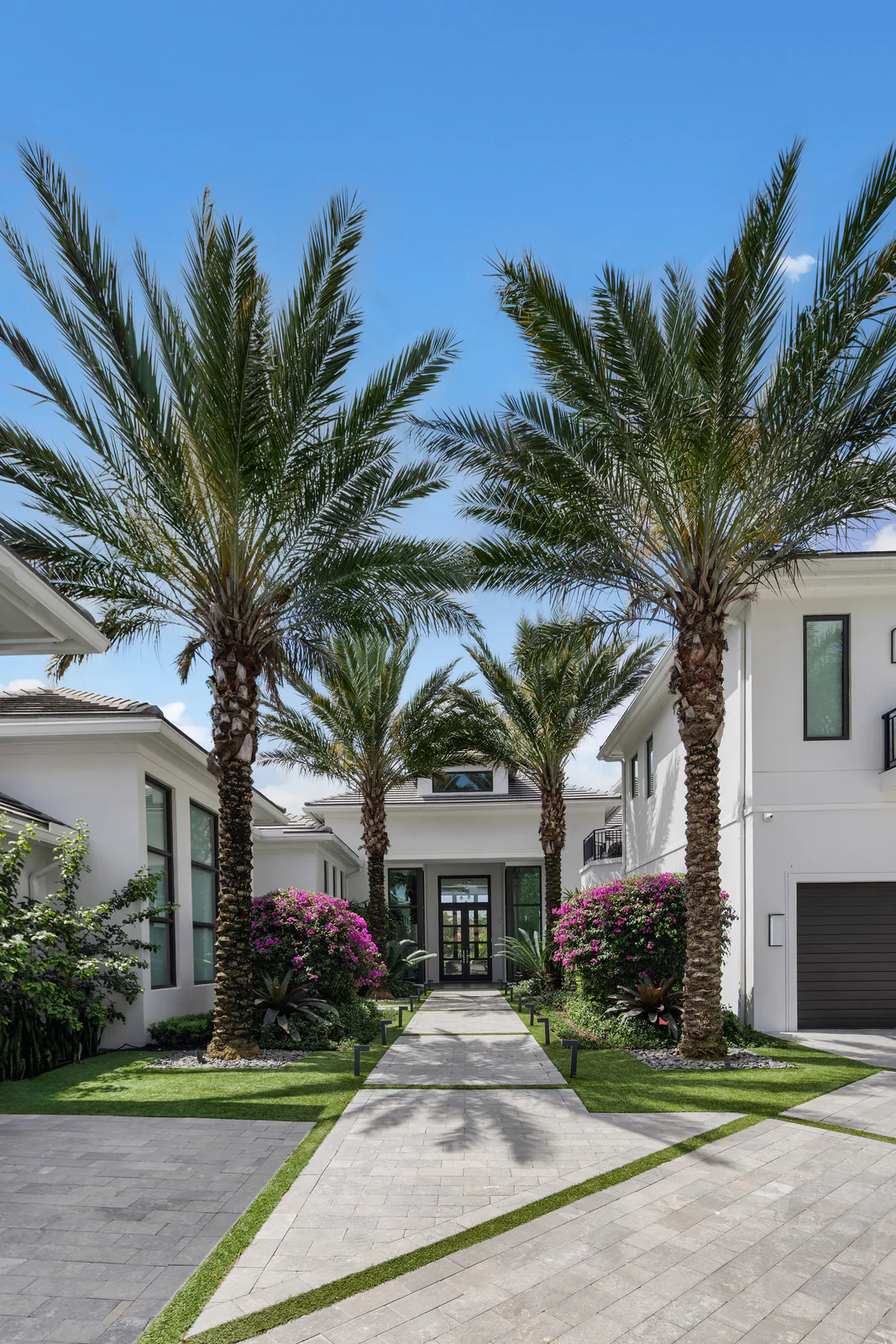 Palm-flanked estate entry, by Power Group Care in Palm Beach County